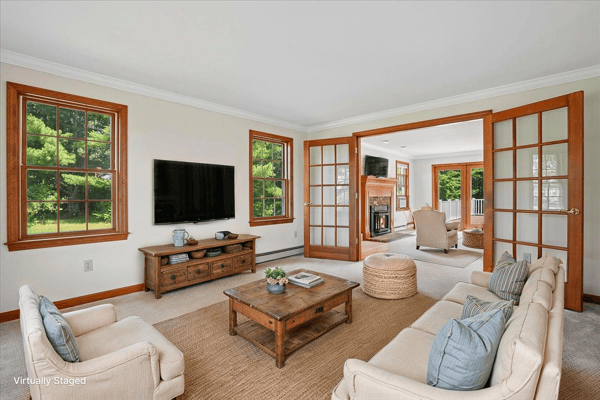 Spacious living room featuring large windows, a cozy fireplace, and a seamless flow to outdoor views.
