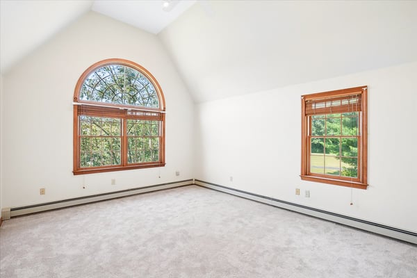 Bright and airy bedroom featuring large windows that invite abundant natural light and picturesque views.