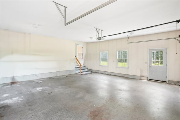 Spacious garage with ample natural light, featuring easy access to the backyard through a side door.