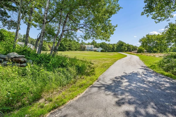 Nestled on a spacious lot, this property features a winding driveway and picturesque natural surroundings.
