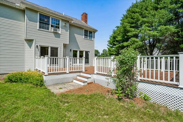 This spacious home features a large deck and lush backyard, perfect for outdoor gatherings and relaxation.