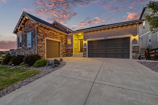 Discover this inviting home with modern architecture, landscaped grounds, and a welcoming driveway at sunset.