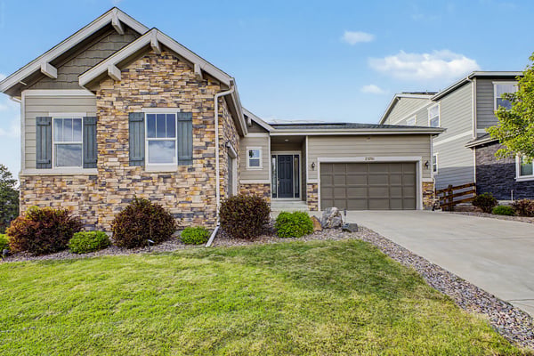 Updated home featuring a unique stone facade, landscaped yard, and convenient driveway access in a desirable neighborhood.