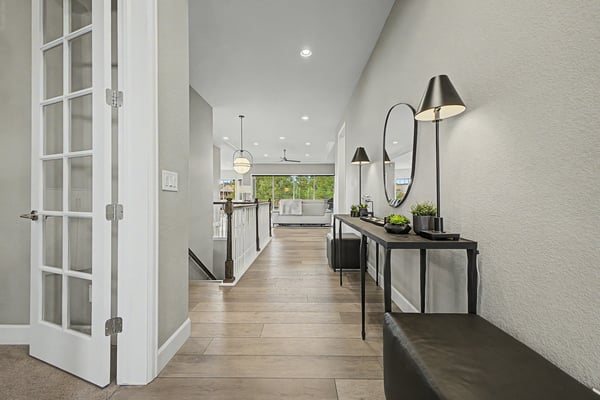 Bright, open hallway leads to a spacious living area, featuring modern fixtures and inviting natural light.