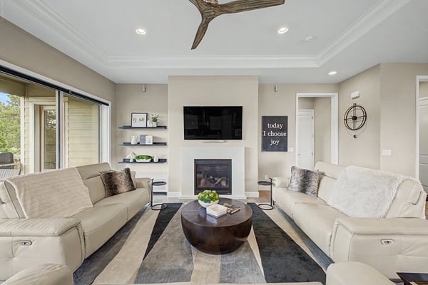 Bright and inviting living room featuring modern furnishings, a cozy fireplace, and large windows for natural light.