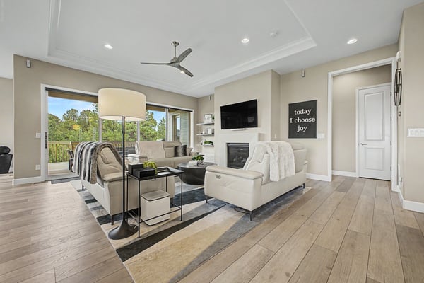 Bright and inviting living room with modern finishes, large windows, and a cozy fireplace, perfect for gatherings.
