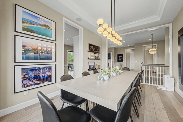 Bright dining area featuring a modern table, gallery artwork, and open flow to the living space.
