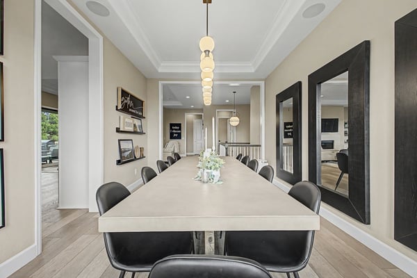 Discover a spacious dining area perfect for gatherings, featuring modern lighting and large mirrors for added depth.