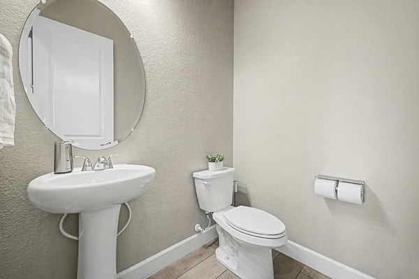 Modern bathroom featuring a sleek round mirror and minimalist design, enhancing spatial efficiency and functionality.