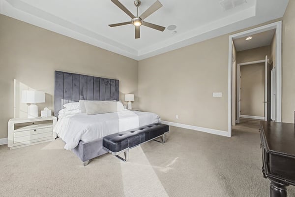 Spacious master bedroom featuring a modern design, large windows, and a cozy seating area for relaxation.