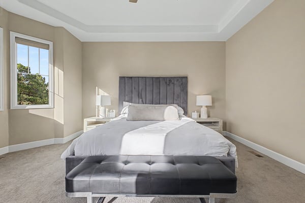 Spacious and inviting bedroom featuring large windows and modern furnishings, perfect for relaxation and comfort.
