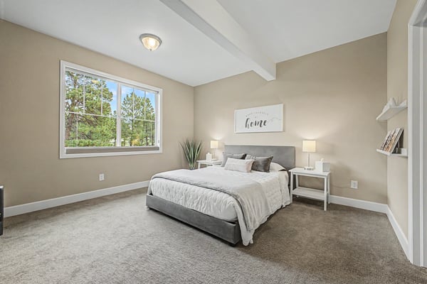 Spacious bedroom featuring large windows, neutral tones, and versatile decor options for personalized touches.