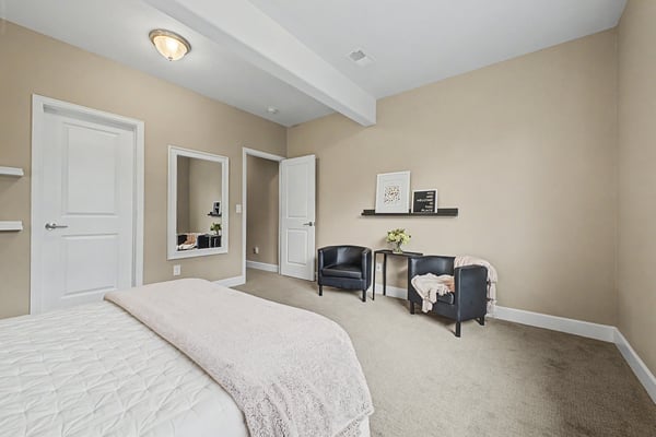 Bright and spacious bedroom featuring modern touches, ample natural light, and functional seating areas.