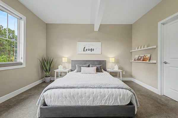 Bright and airy bedroom featuring large windows, modern decor, and a spacious layout for comfortable living.