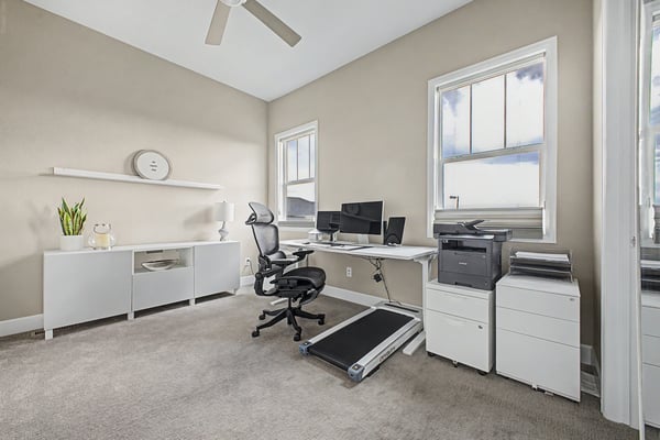 Bright and functional home office with modern furnishings and ample natural light, ideal for productivity.
