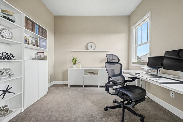 Bright home office featuring modern furnishings and built-in shelving, ideal for productivity and comfort.