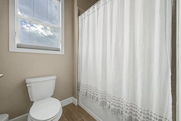 Bright and inviting bathroom featuring a large window, modern fixtures, and a relaxing atmosphere.