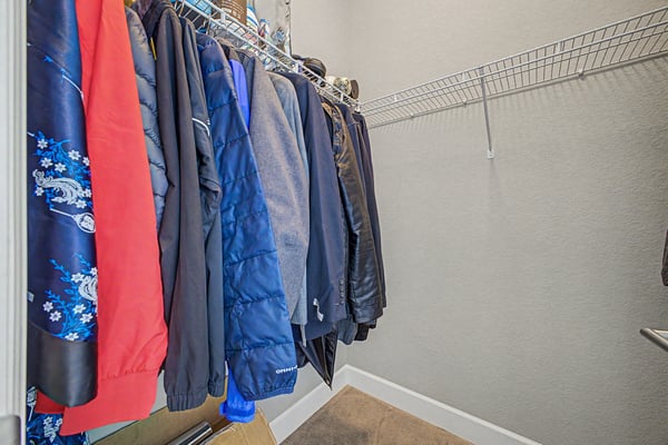 Spacious closet featuring ample hanging space, perfect for organizing your outerwear and accessories.
