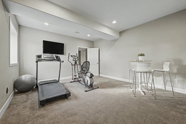 Versatile workout room featuring space for exercise equipment and a small dining area for post-workout meals.