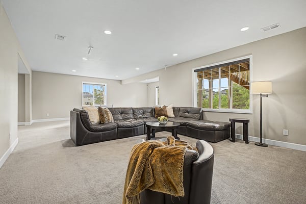 Spacious living area with ample natural light, featuring a cozy sectional and inviting atmosphere for relaxation.