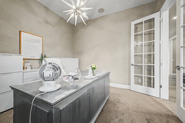 Bright and airy office space featuring a sleek desk, modern lighting, and ample natural light.