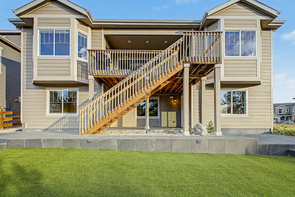 Spacious two-story home featuring a welcoming entrance with a large deck and ample outdoor space.