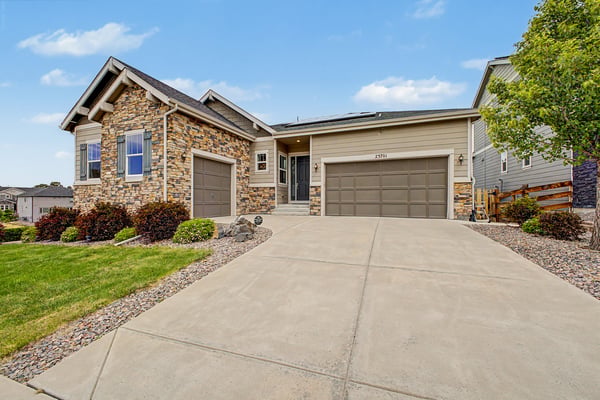 This well-maintained home features a spacious driveway and inviting stone accents in a quiet neighborhood.