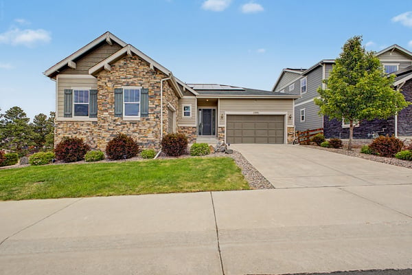 Modern home featuring a stone exterior, landscaped yard, and convenient garage in a welcoming neighborhood.