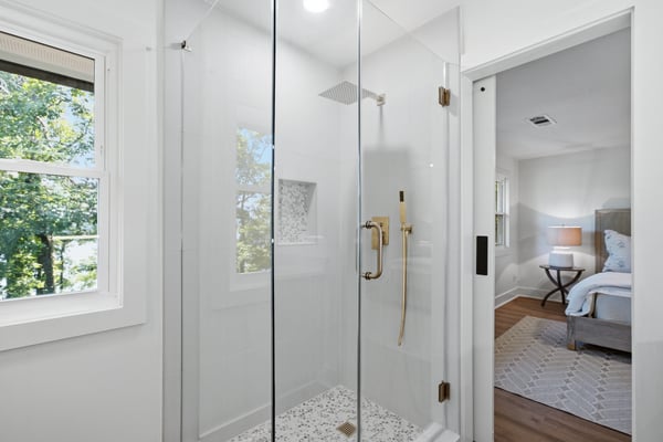 Modern glass shower with sleek finishes, featuring abundant natural light and peaceful views from nearby windows.