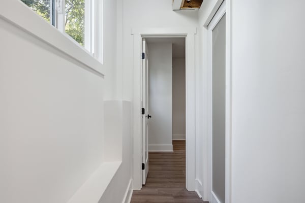Bright and inviting hallway with natural light, leading to additional living spaces and modern features.