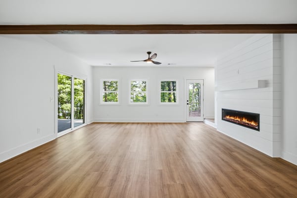 Spacious living area features abundant natural light and modern fireplace, perfect for relaxation and gatherings.