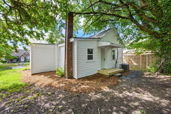Cozy home with a spacious backyard, offering potential for garden or outdoor entertainment.
