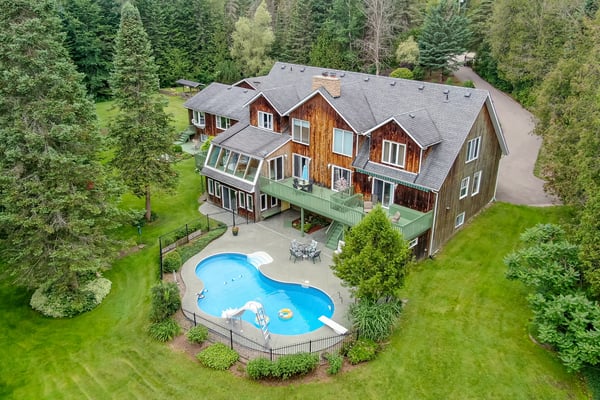 Expansive property featuring a private pool, lush greenery, and multiple outdoor spaces for relaxation and entertainment.