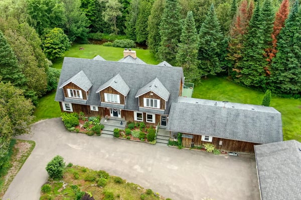 Spacious home surrounded by lush greenery, featuring multiple levels and ample outdoor space for recreation.