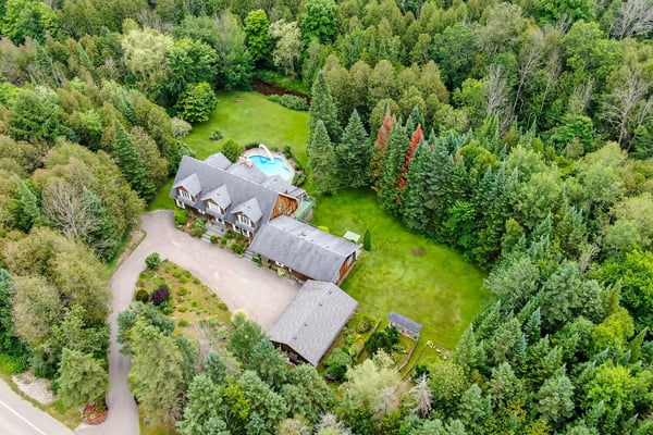 Discover a spacious retreat surrounded by lush greenery, featuring a swimming pool and expansive outdoor area.