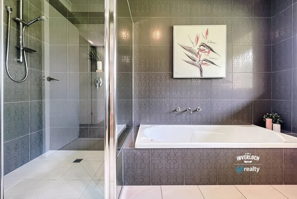 Spacious bathroom featuring a double vanity, modern shower, and relaxing bathtub for ultimate comfort.