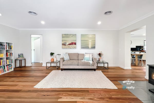 Bright and spacious living area featuring warm wooden floors, modern artwork, and an inviting atmosphere.