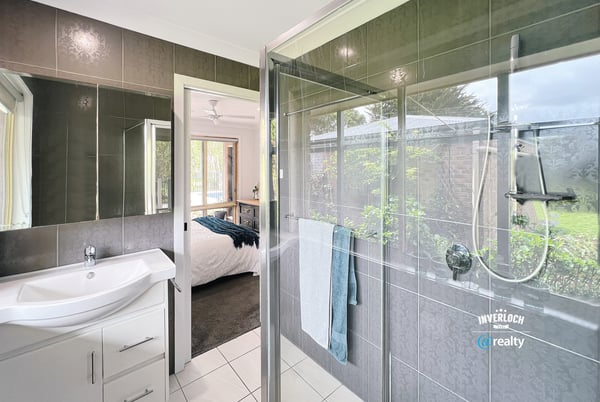 Modern bathroom featuring a spacious shower, sleek fixtures, and a seamless view of the landscaped garden.
