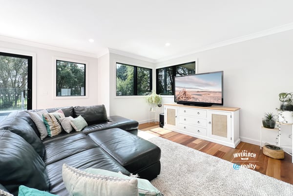 Spacious living area features large windows, modern furnishings, and ample natural light for a welcoming atmosphere.