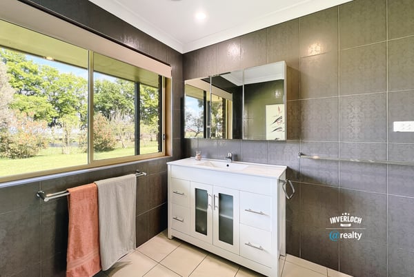 Bright and airy bathroom featuring modern fixtures, ample natural light, and scenic garden views.