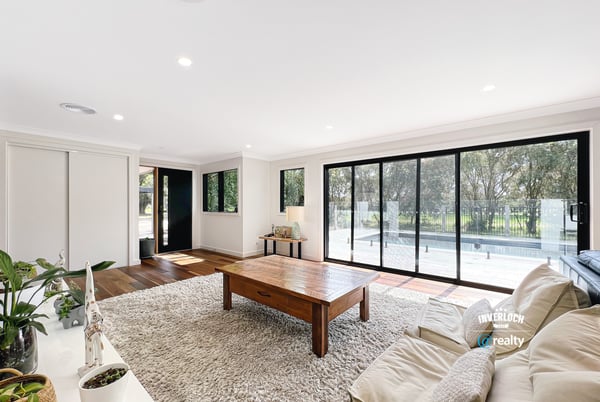 Spacious living area features large windows, abundant natural light, and direct access to outdoor spaces.