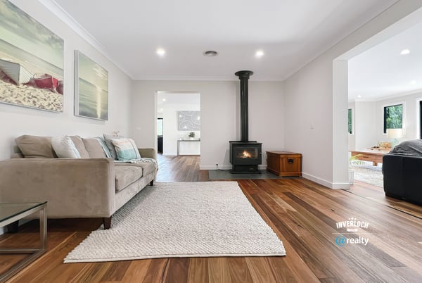 Spacious living area featuring natural light, modern decor, and a cozy fireplace, perfect for gatherings.