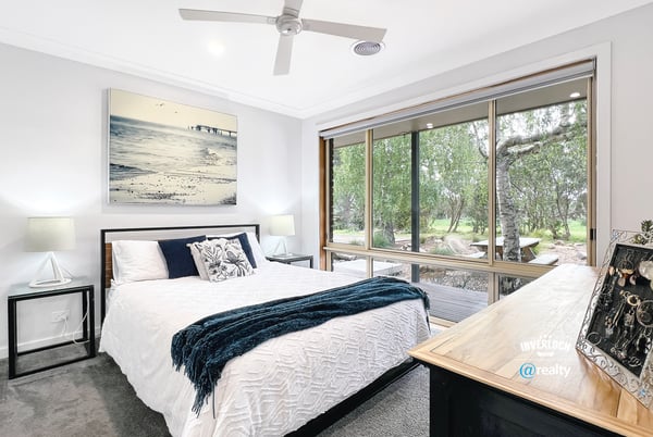 Bright bedroom with large windows offering scenic views and modern finishes for comfortable living.