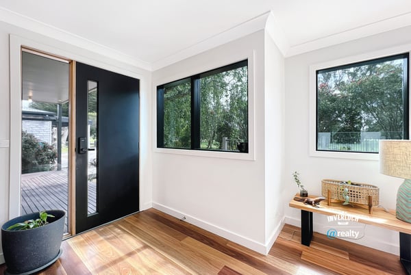 Bright entryway featuring large windows and natural light, welcoming you into a spacious home.