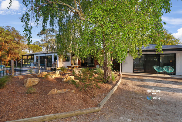 Contemporary home surrounded by lush landscaping, featuring spacious outdoor areas and modern design elements.