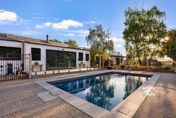 Discover a modern home featuring an inviting outdoor pool and spacious patio, perfect for entertaining.