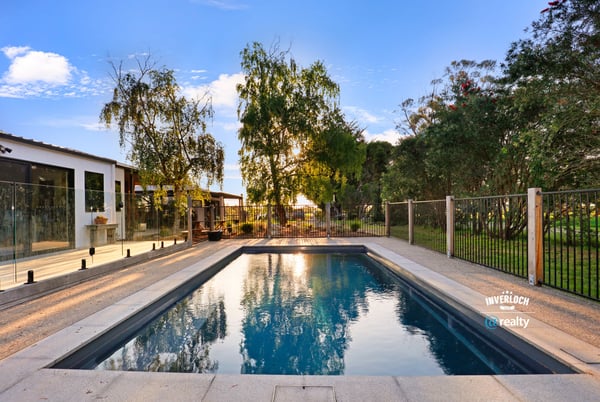 Discover this inviting outdoor space featuring a refreshing pool, surrounded by lush greenery and modern amenities.