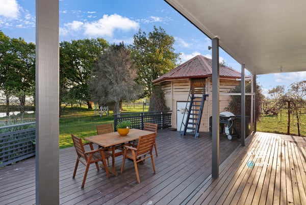 Spacious outdoor deck with direct access to lush greenery, ideal for entertaining and relaxation.