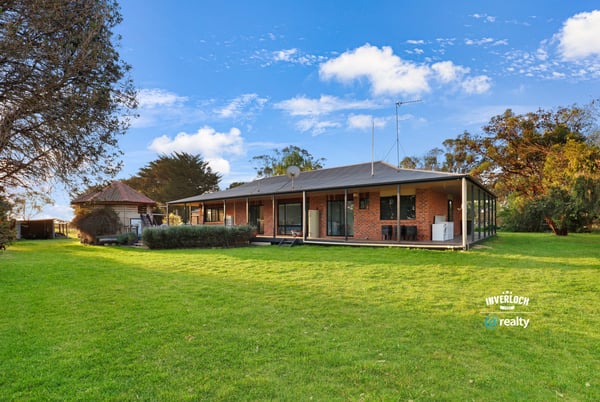 Spacious home set on expansive grounds, featuring large windows and a seamless indoor-outdoor living experience.