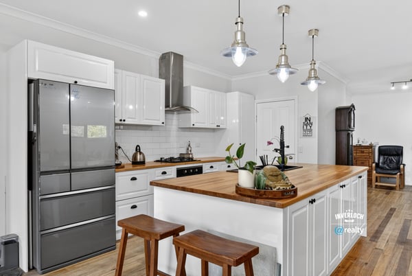 Modern kitchen featuring sleek appliances, a spacious island, and warm wood accents, perfect for culinary enthusiasts.